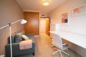 Arbeitszimmer mit höhenverstellbarem Schreibtisch und Schlafcouch